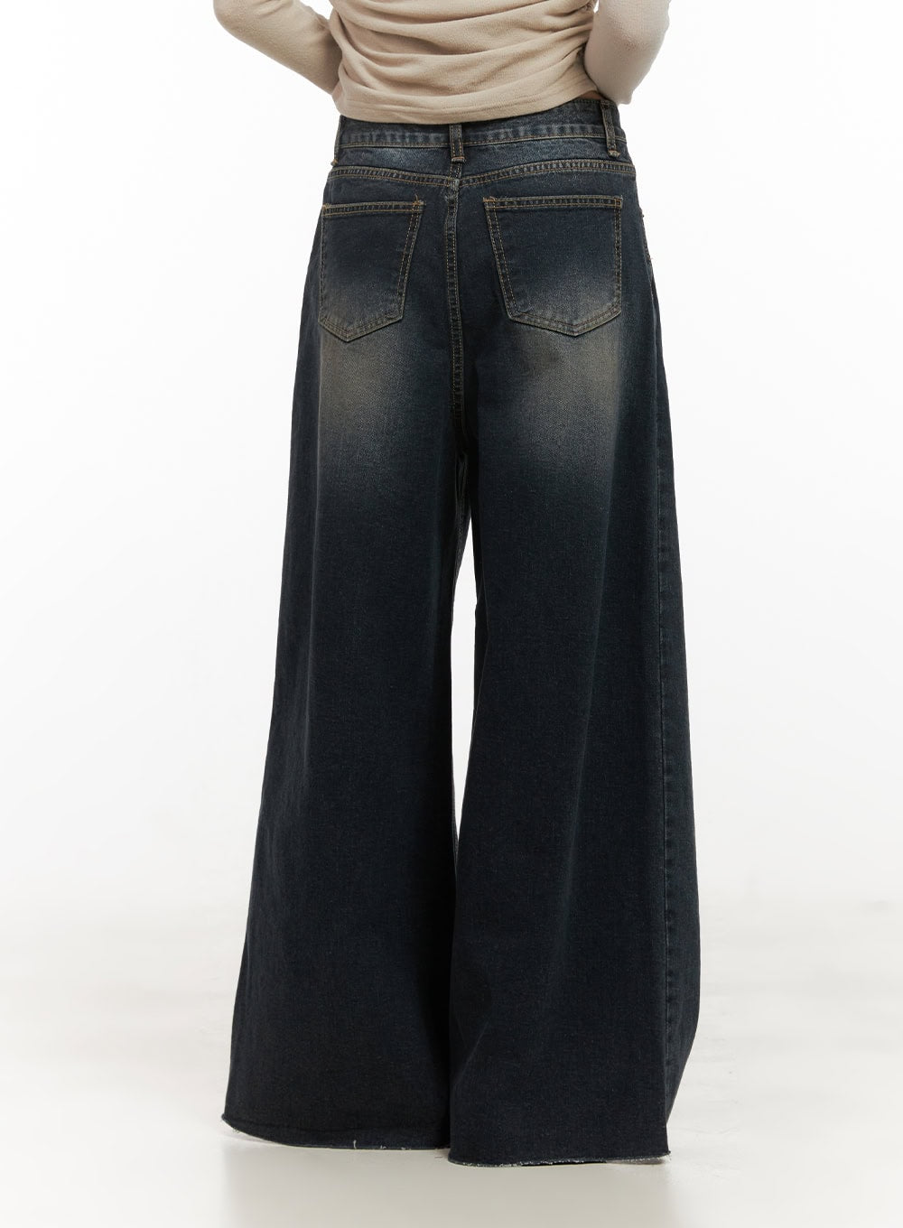 Tasha Low Waist Washed Wide Leg Jeans CD410 in dark blue, back close-up on model, washed denim with twin back pockets, topstitching detail, low waistband, and raw frayed hem on wide-flared legs.