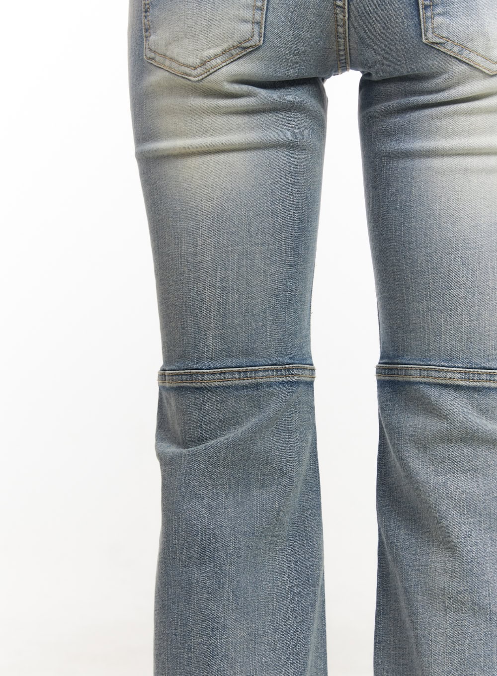 Tracy Washed Bootcut Jeans CF513 in light blue, close-up back detail shot showing horizontal panel seam at knee, washed denim texture, and flared hem construction.