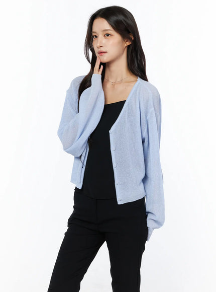 Sheer V-Neck Cardigan CU522 in light blue, side-angle upper-body shot on model, sheer relaxed knit with drop shoulder, layered over black cami and black trousers.