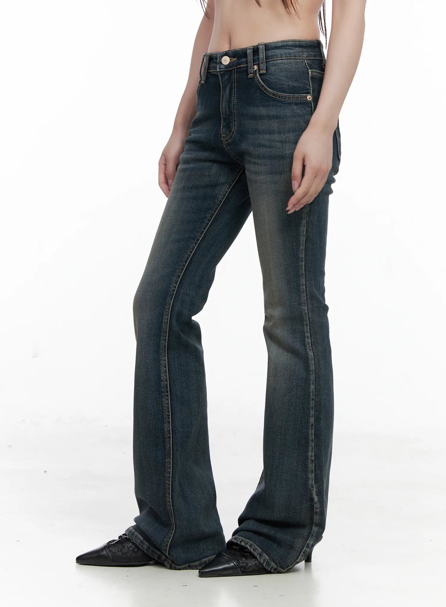 Rosé Washed Bootcut Jeans CO520 in dark blue, side close-up on model, low-rise fit with front pocket and contrast stitching, gradual bootcut flare, washed denim texture.
