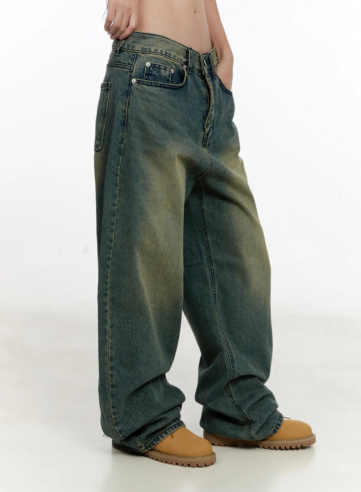 Sooyoung Baggy Vintage Wash Jeans CL531 in dark blue, side view on model, highlighting oversized wide-leg silhouette, yellow-tinted wash, back pocket, and pooling hem over tan boots.