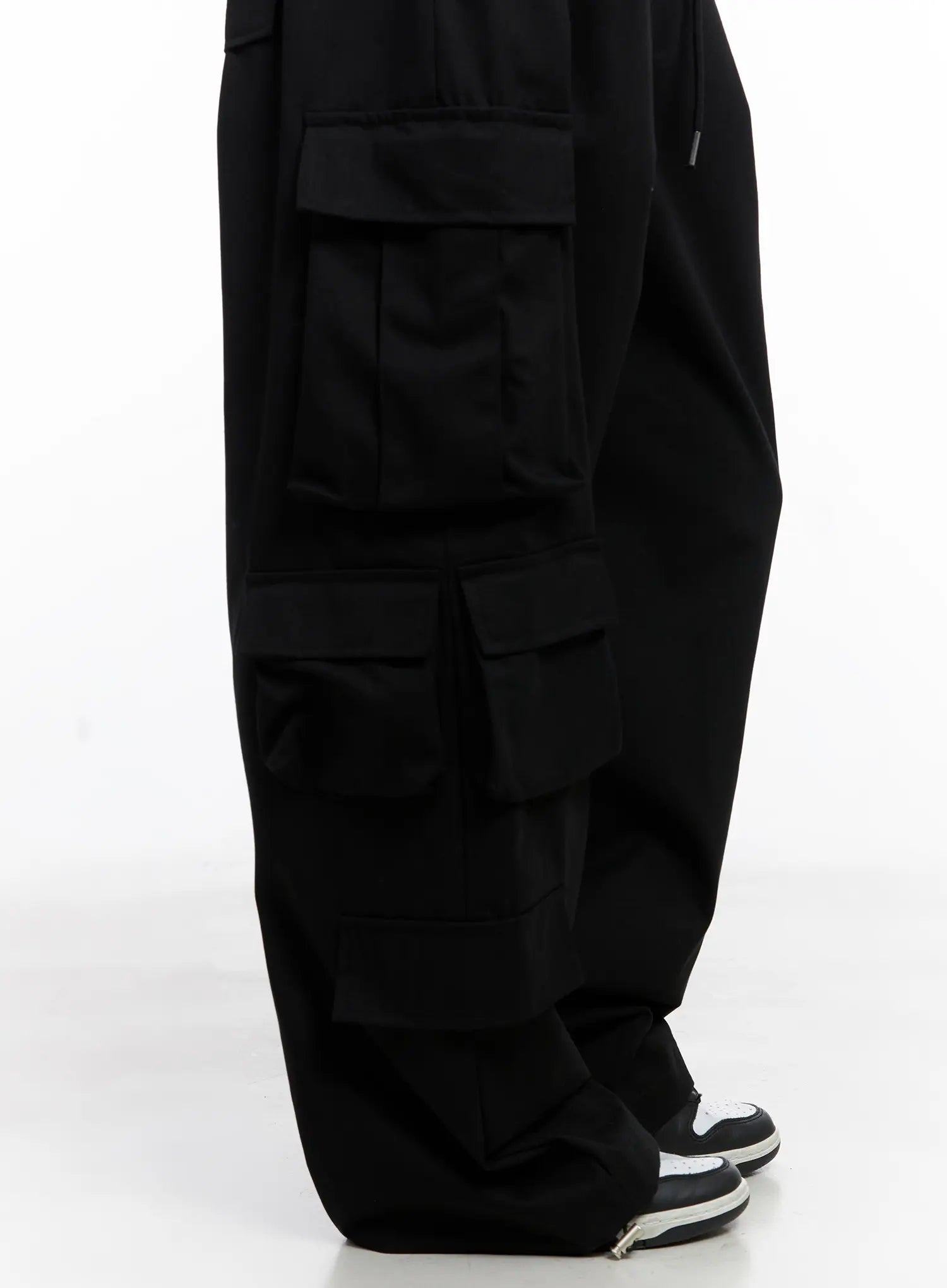 Wide Leg Cargo Pants CC1109 in black, side close-up detail shot, triple-stacked flap cargo pockets running down leg, wide cotton leg silhouette, sneaker hem stack.