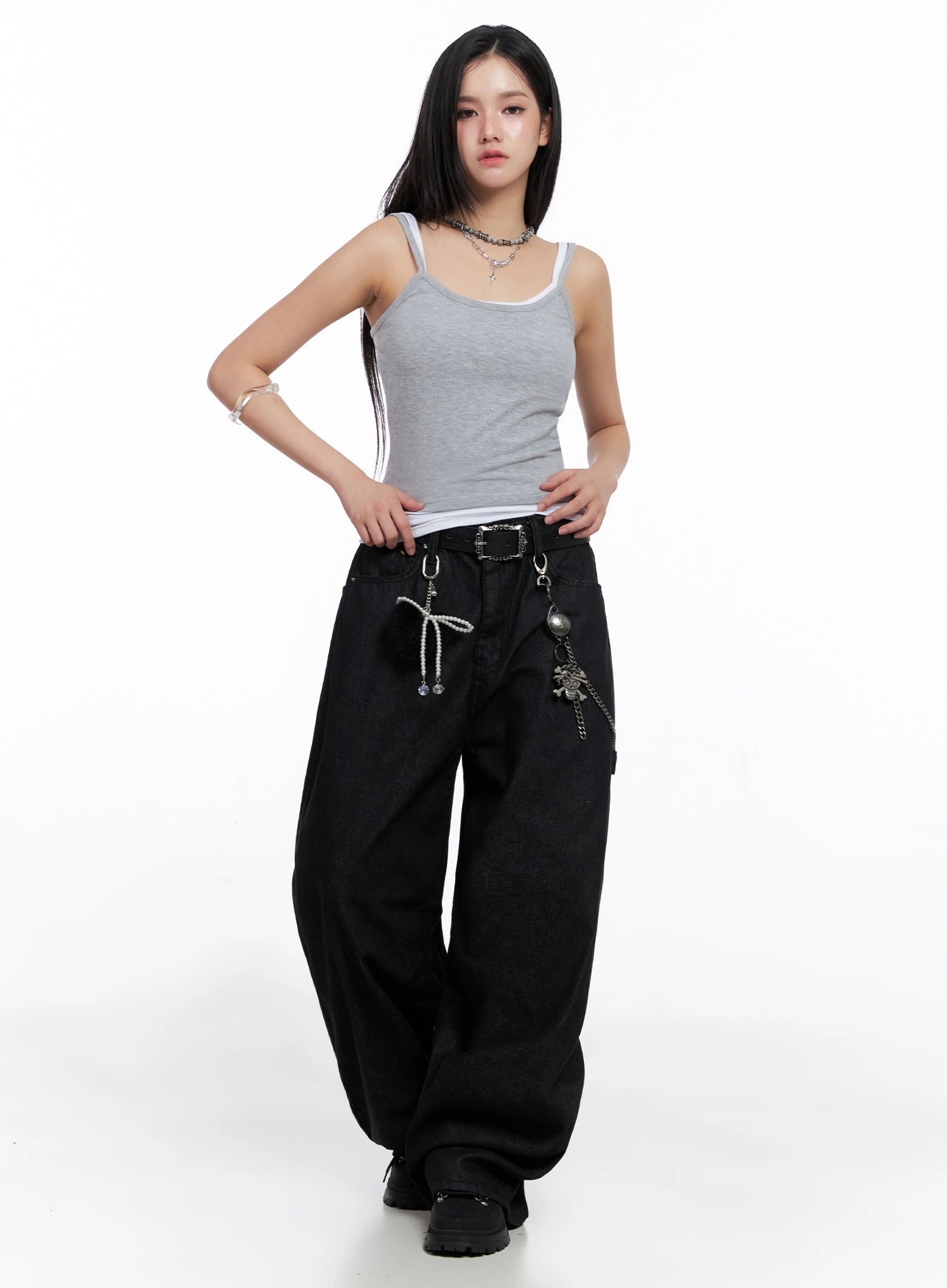 Lea Cross-Patch Baggy Jeans IS525 in black, front full-length shot on model, wide-leg baggy cotton denim with chain and charm waist accessories, styled with grey layered cami top and black boots.
