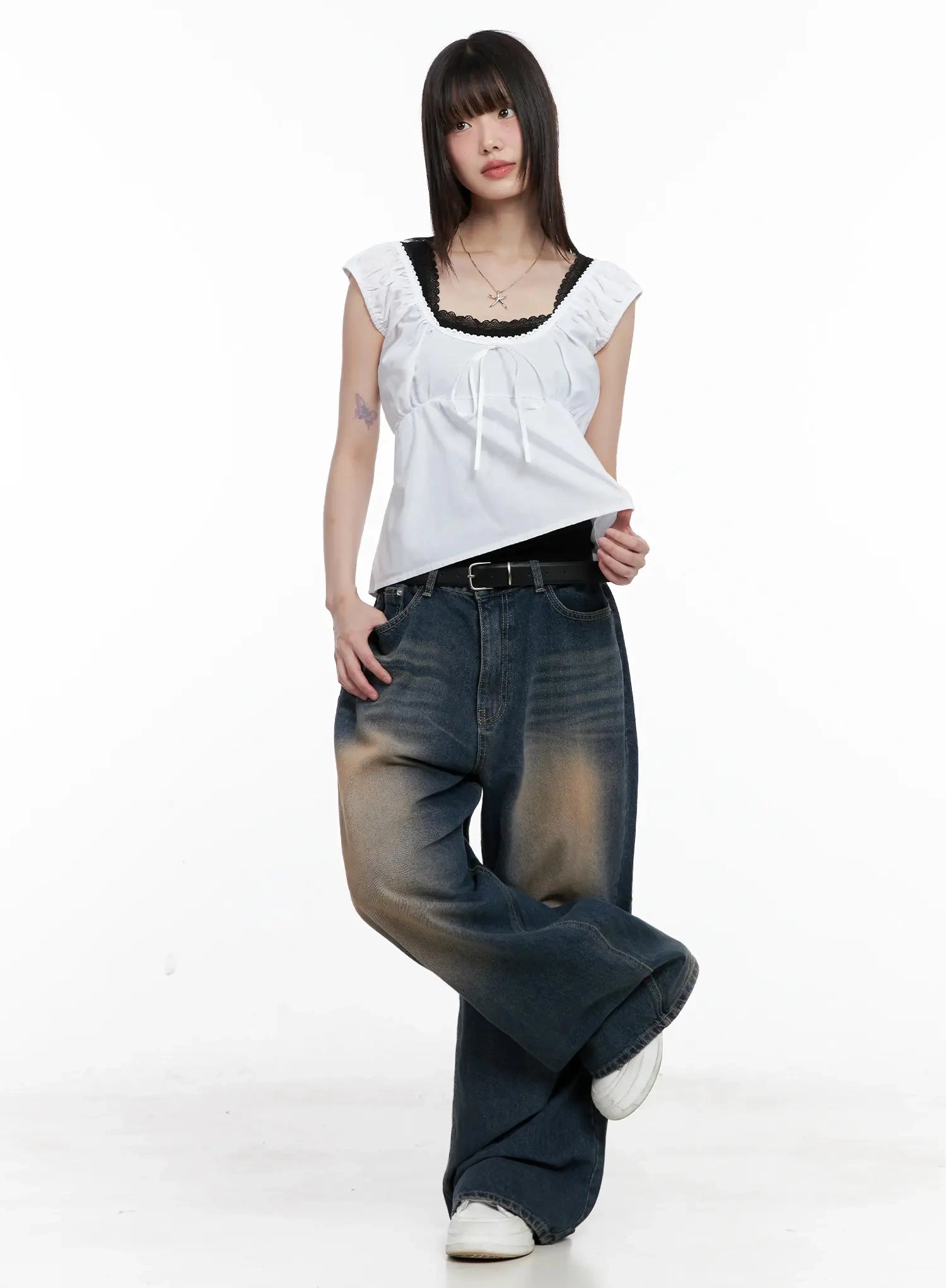Solji Acid Washed Wide-Leg Jeans IL531 in dark blue, full-body angled shot on model lifting top hem, one leg crossed, acid-wash fading and wide silhouette visible with belt.