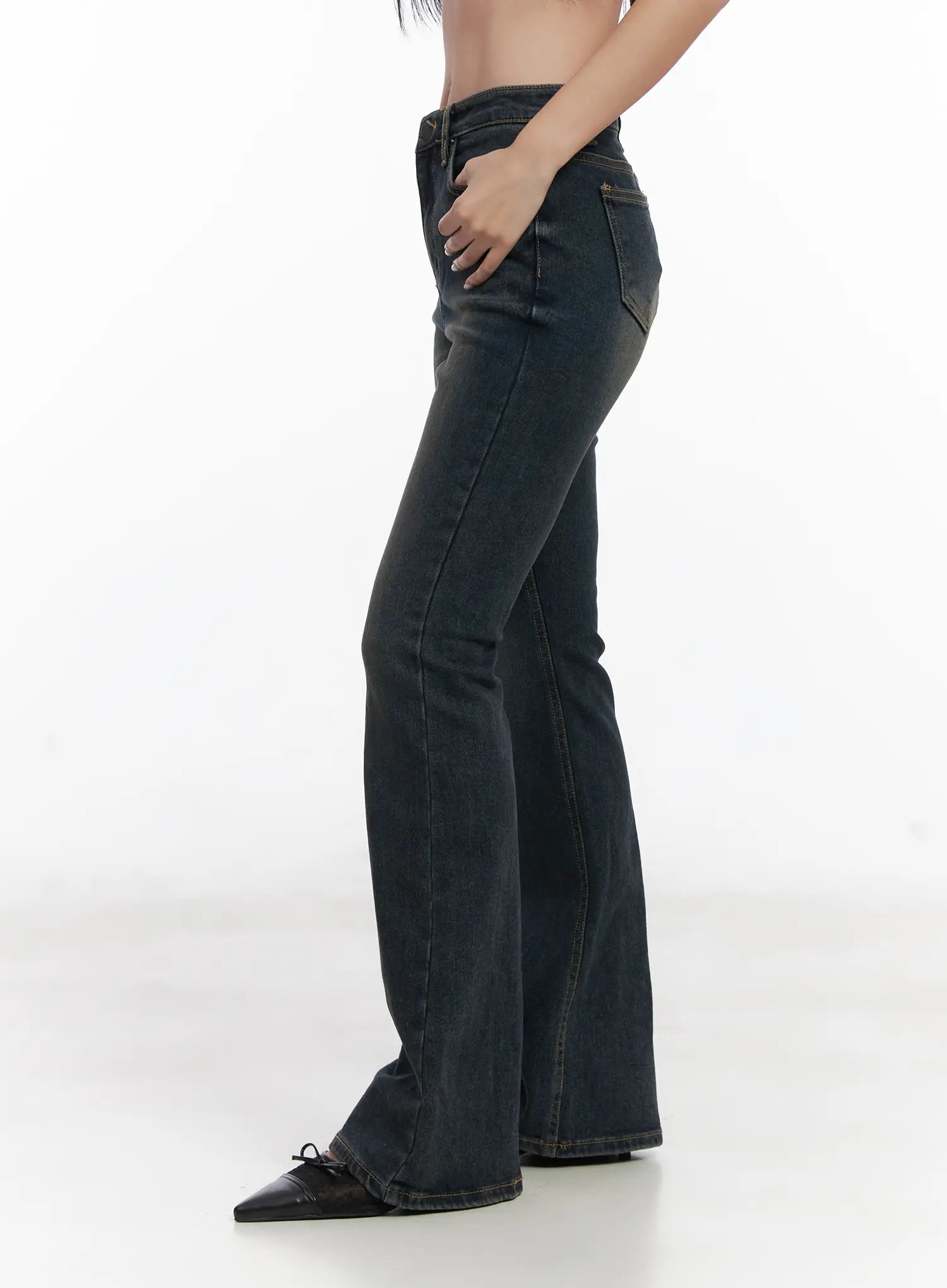 Jay Dark-Wash Bootcut Jeans CD501 in dark blue, close side view on model from waist to hem, slanted front pocket detail, subtle fading, bootcut flare leg, worn with black bow-tie flats.