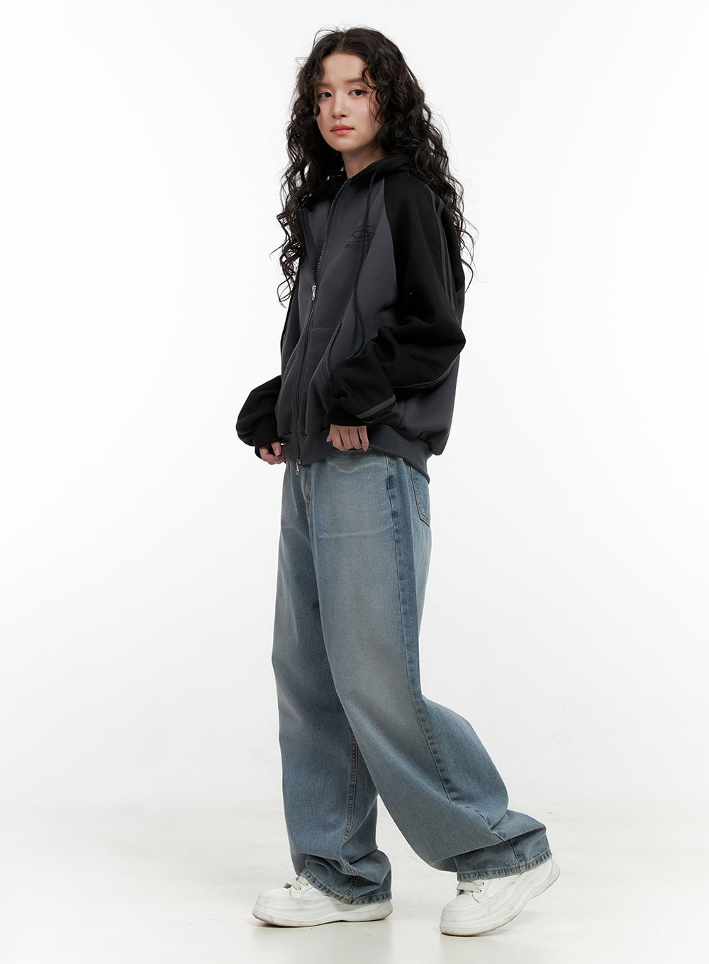 Taryn Chic Wide-Leg Jeans ON404 in light blue, three-quarter side shot on model, baggy washed denim with floor-grazing wide leg, paired with oversized black zip hoodie.