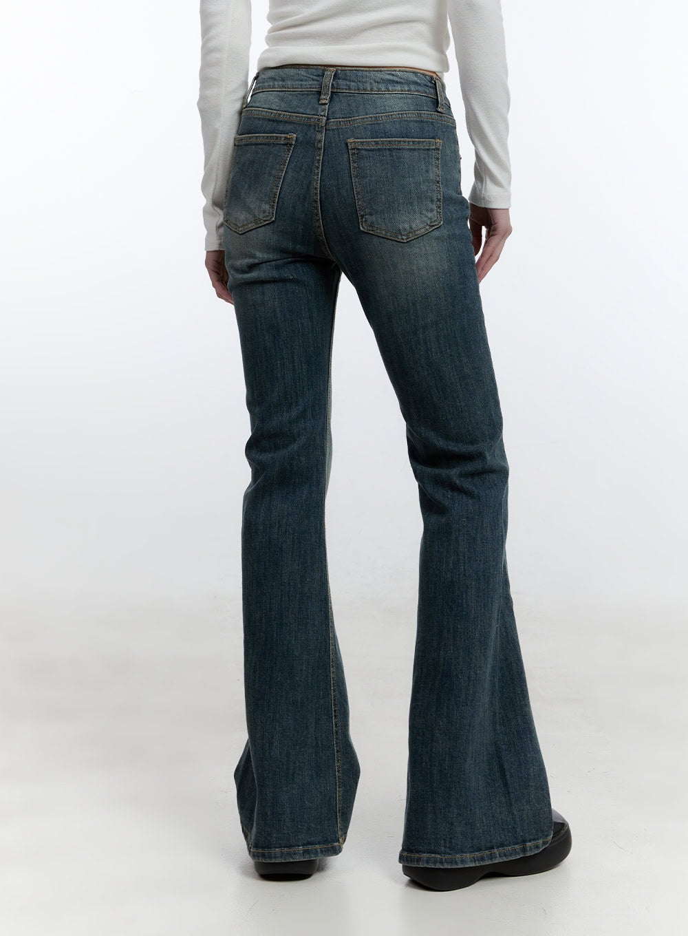 Mallory Skinny Bootcut Jeans CJ520 in blue, back view on model, washed denim with dual back patch pockets and subtle fading, bootcut flare hem shown from behind.