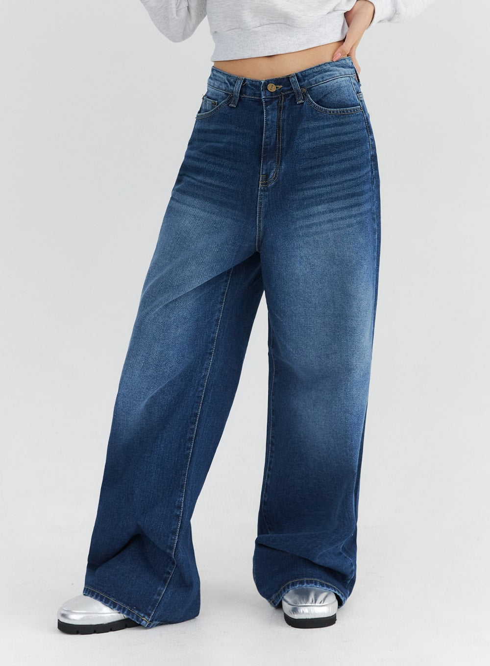 Washed Blue Wide Jeans CN301 in blue, angled front lower-body close-up on model, showcasing ultra-wide leg opening, washed indigo fade, and contrast stitching detail on cotton denim.
