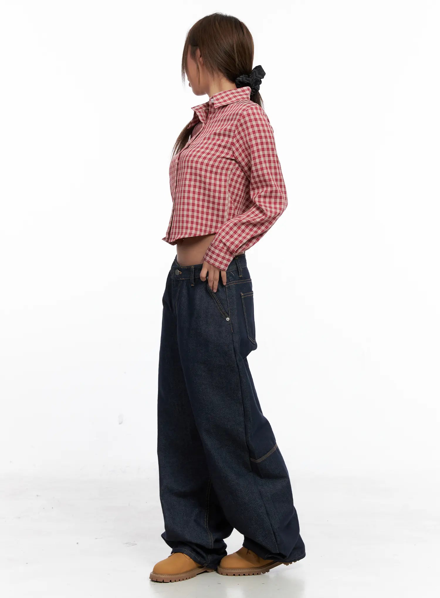 Relaxed Fit Dark Denim Jeans CS522 in dark blue, side styling shot, model in red plaid crop shirt with scrunchie, wide-leg balloon leg fully visible, tan boots, casual street style.