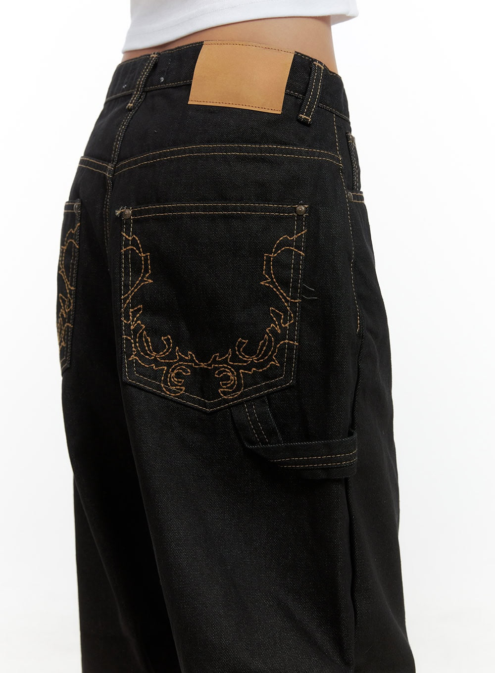 Mara Relaxed Fit Pocketed Cotton Wide Leg Jeans CS426 in black, back detail close-up on model, ornate floral embroidery on back pockets, tan leather patch, contrast golden topstitching on cotton denim.