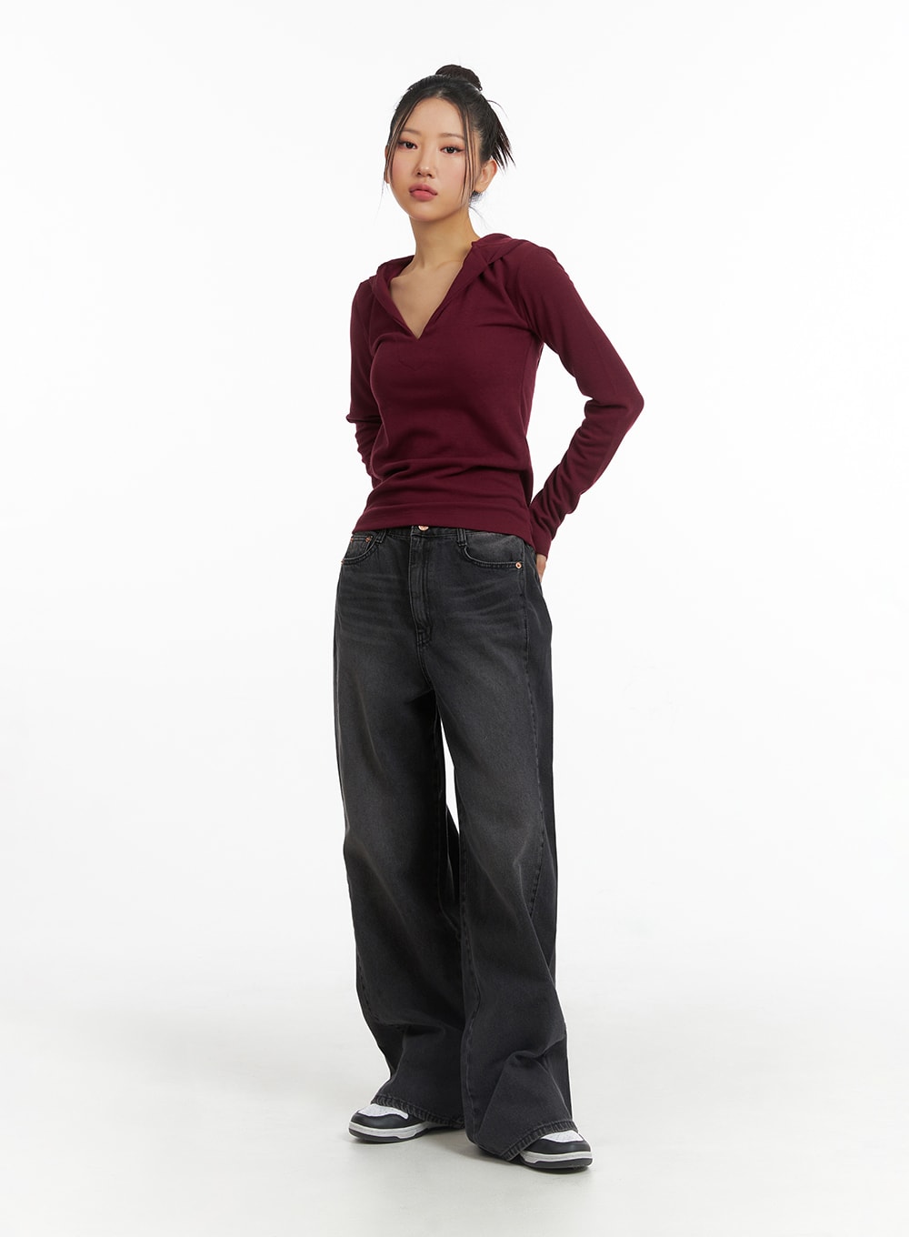 Washed Denim Wide-Leg Jeans CJ426 in black, full-body slight angle shot on model with hand in pocket, wide-fit washed cotton denim, paired with burgundy hooded top and sneakers.