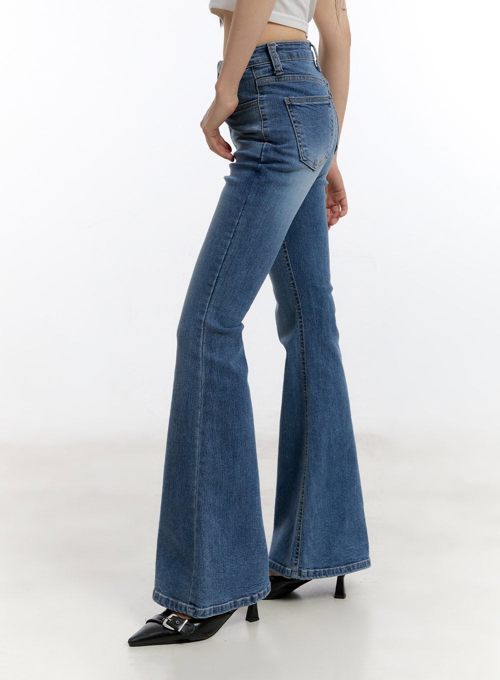 Maris Hip-Pad Bootcut Jeans CA508 in blue, side close-up on model, high-waist washed denim showing slim thigh fit and wide bootcut flare from hip to hem, with black heels.