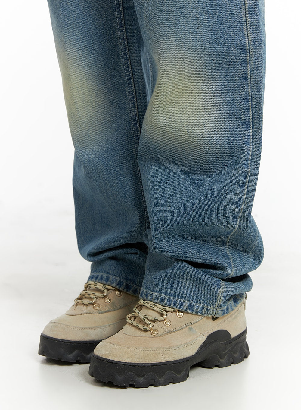 Recycled Washed Jeans (Unisex) CM425 in blue, close-up hem and ankle detail on model, straight leg hem pooling over chunky beige hiking-style sneakers.