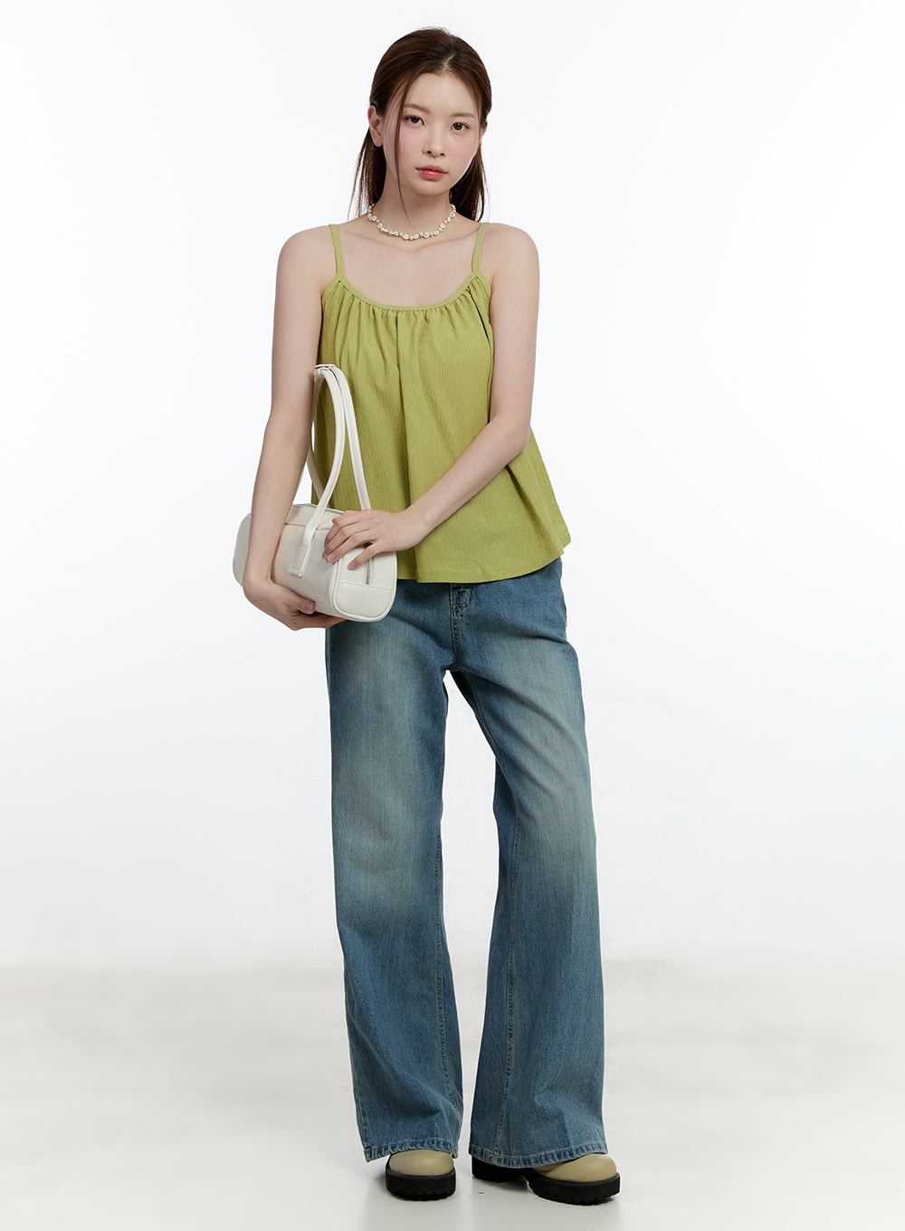 Aleks Relaxed-Fit Flared Jeans CM521 in blue, full front view on model, wide-fit washed denim flared jeans paired with green spaghetti-strap cami and white mini bag.