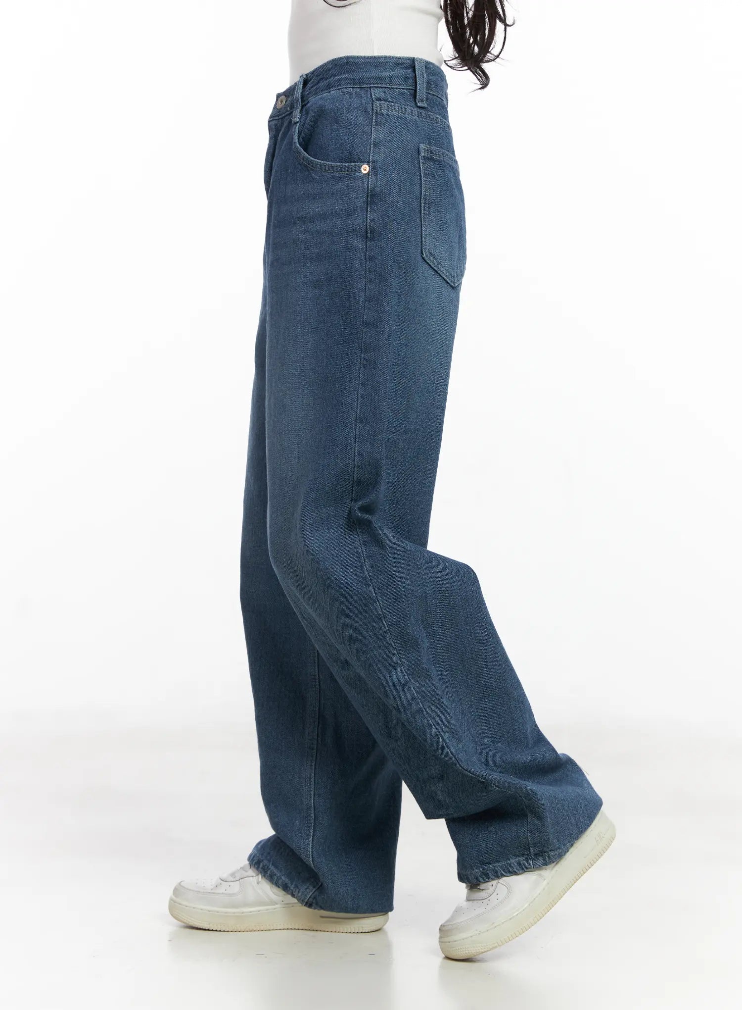 Mariam Baggy Jeans CN526 in blue, close side view on model, showing back pocket detail and wide-leg drape in washed cotton denim, with white sneakers.