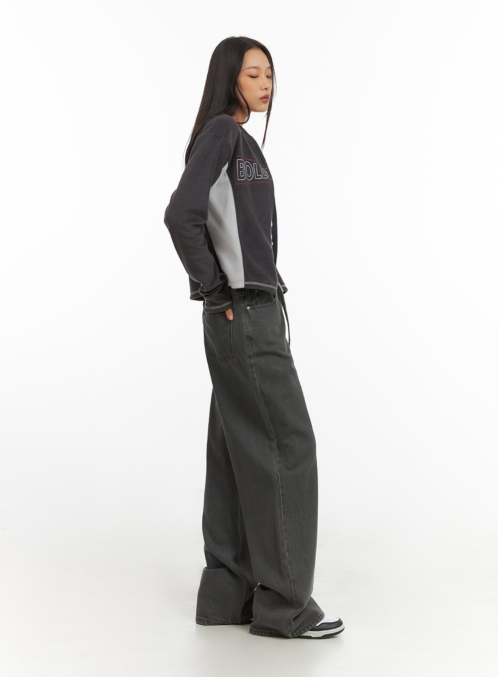 Emery Cotton Strap Baggy Jeans IO409 in dark gray, side full-length view on model, floor-grazing wide leg with strap visible, layered with oversized graphic sweatshirt.