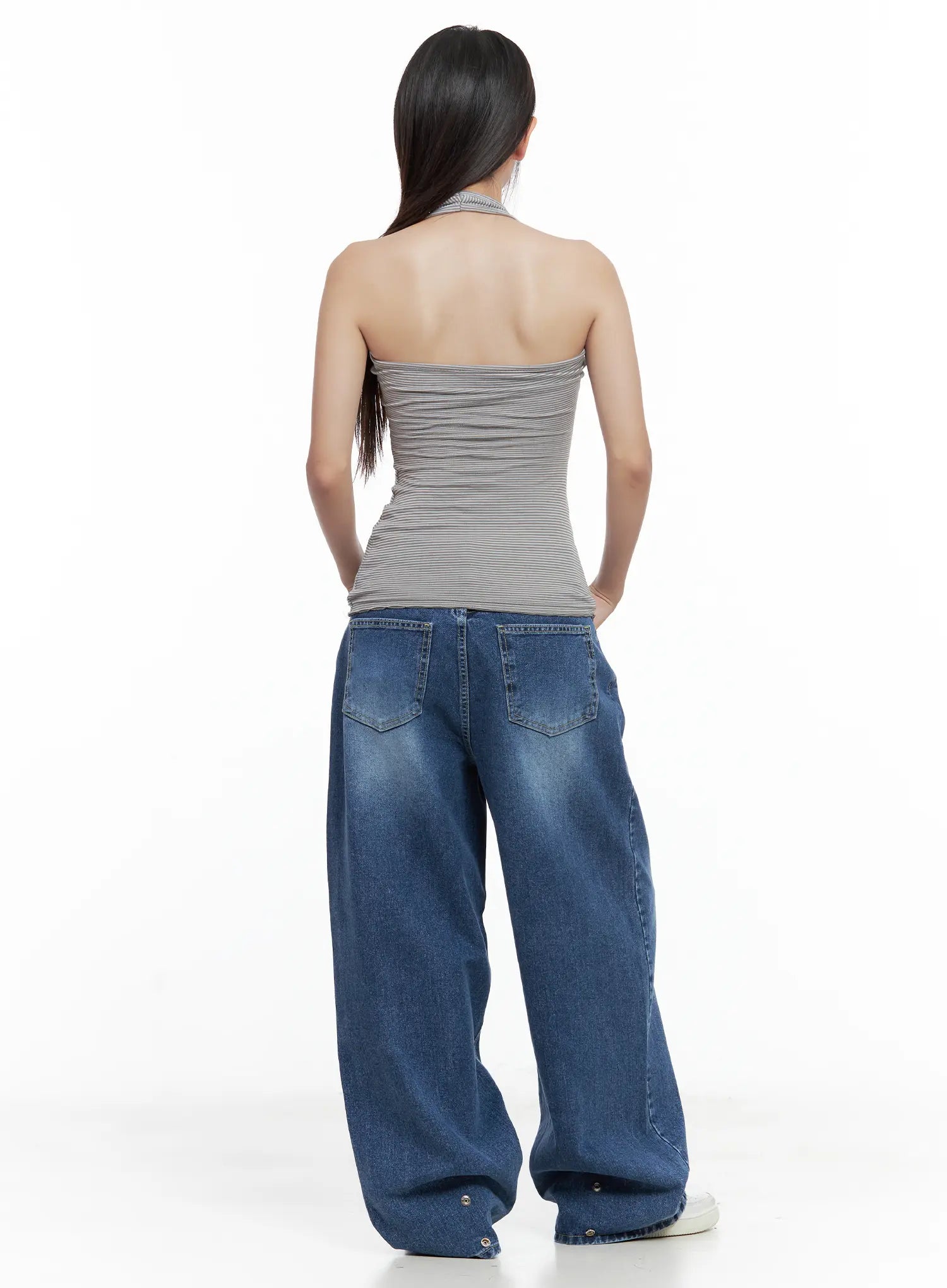 Hayoung Washed Wide-Leg Denim Jeans CL509 in dark blue, back view on model, two rear patch pockets with washed fading, snap-button hem detail, paired with grey halter top and white sneakers.