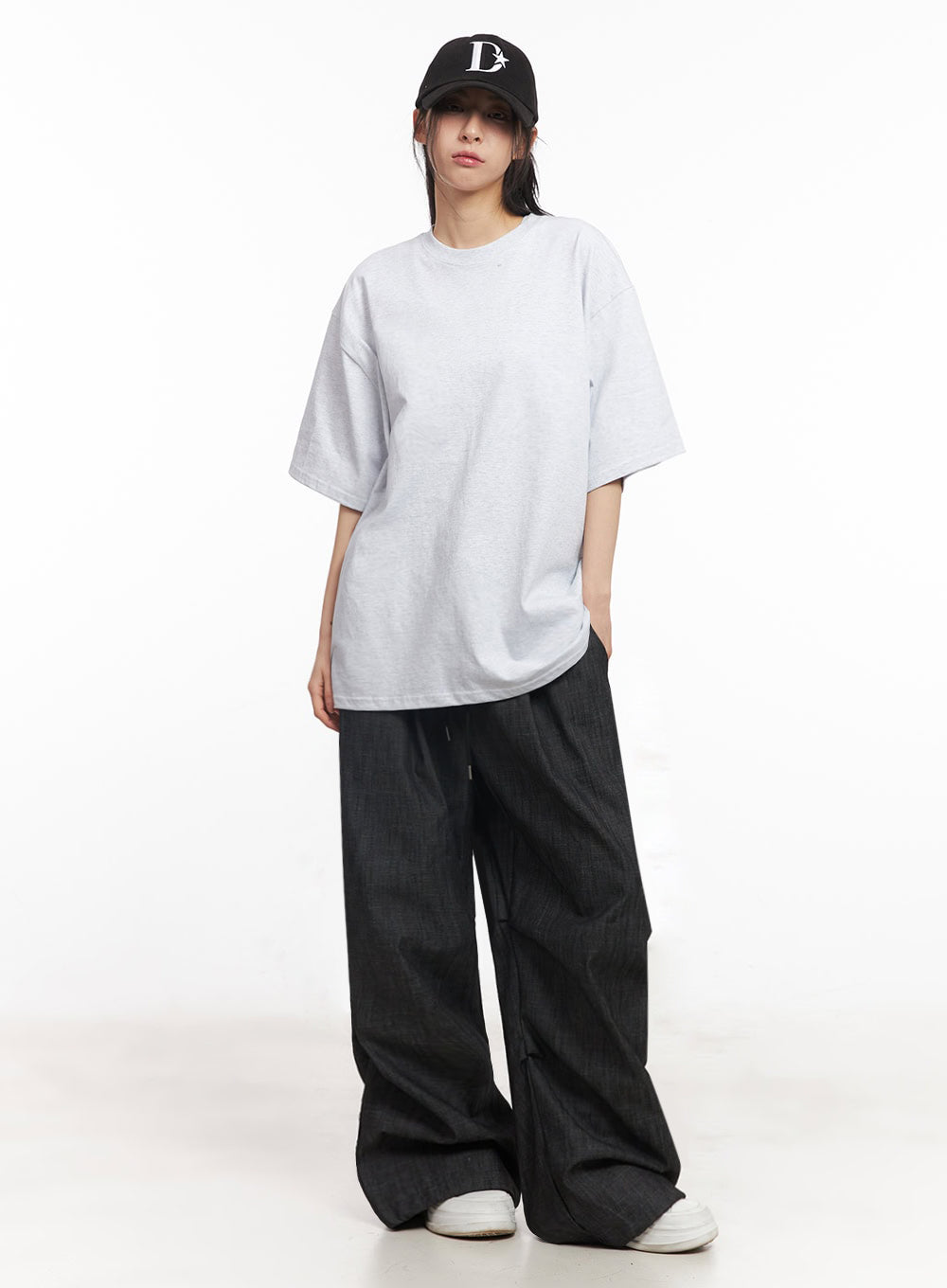 Pintuck Denim Sweatpants IY529 in black, front three-quarter view on model wearing black cap, baggy wide-fit cotton denim with drawstring waist, styled with grey tee and white sneakers.