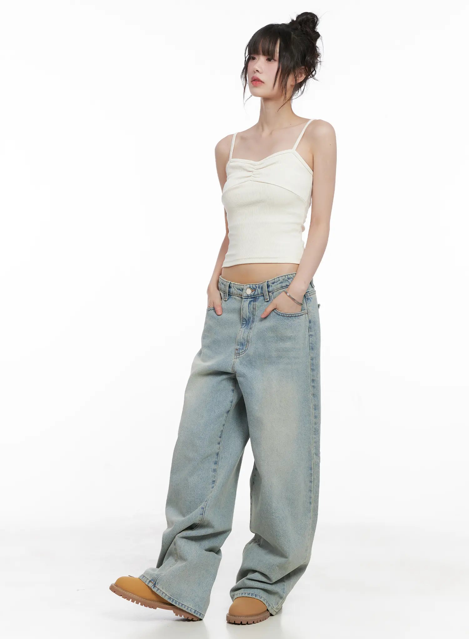 Lilly Light Wash Baggy Jeans CG519 in light blue, three-quarter front view on model in cream cami top, low-rise wide fit with hands in pockets, long length pooling at tan boots.
