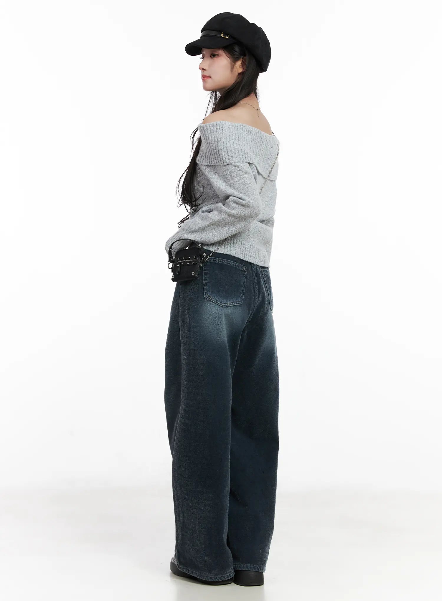 Zariah Baggy Jeans CN526 in dark blue, side editorial shot on model with gray off-shoulder knit and baker boy cap, showing baggy wide leg and back pocket.