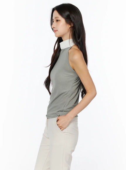 Neck-Tie Halter Top CU522 in dark green, side profile view on model, sleeveless halter neckline with cream tie, body-skimming knit silhouette, paired with cream wide-leg trousers.