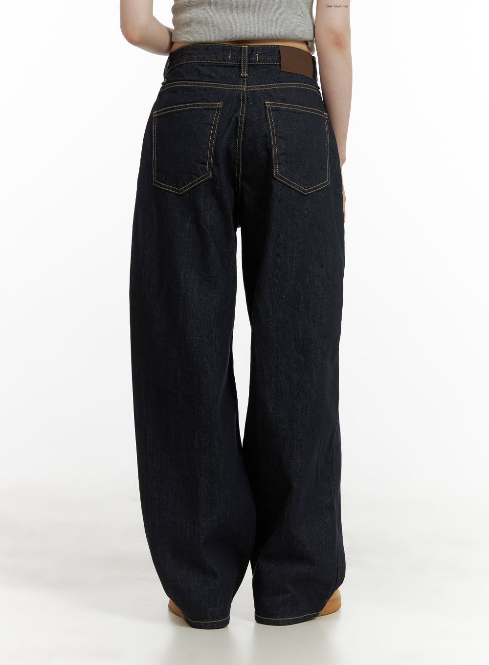 Stitch Detail Baggy Jeans CU410 in dark blue, back view on model, contrast topstitching on back pockets, brown leather waistband patch, baggy wide-leg denim silhouette.