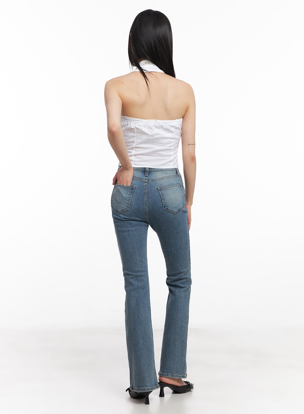 Cassy Slim Washed Flared Jeans CY512 in blue, full back view on model, showing dual back pockets and subtle flare, paired with white halter top and black heeled mules.