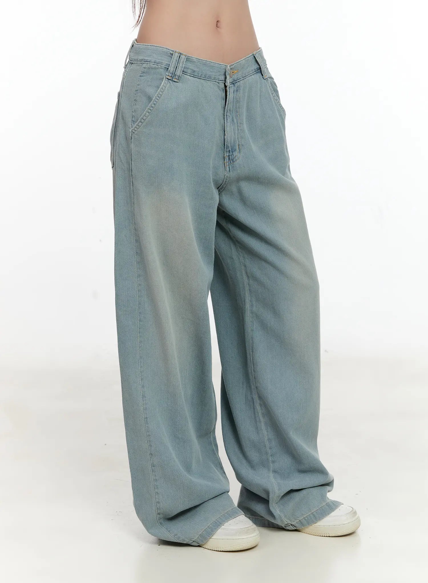Huening Wide-Leg Jeans CL531 in blue, side-angle product shot on model, washed low-rise wide-leg denim highlighting roomy leg silhouette and side pocket detail, with white sneakers.