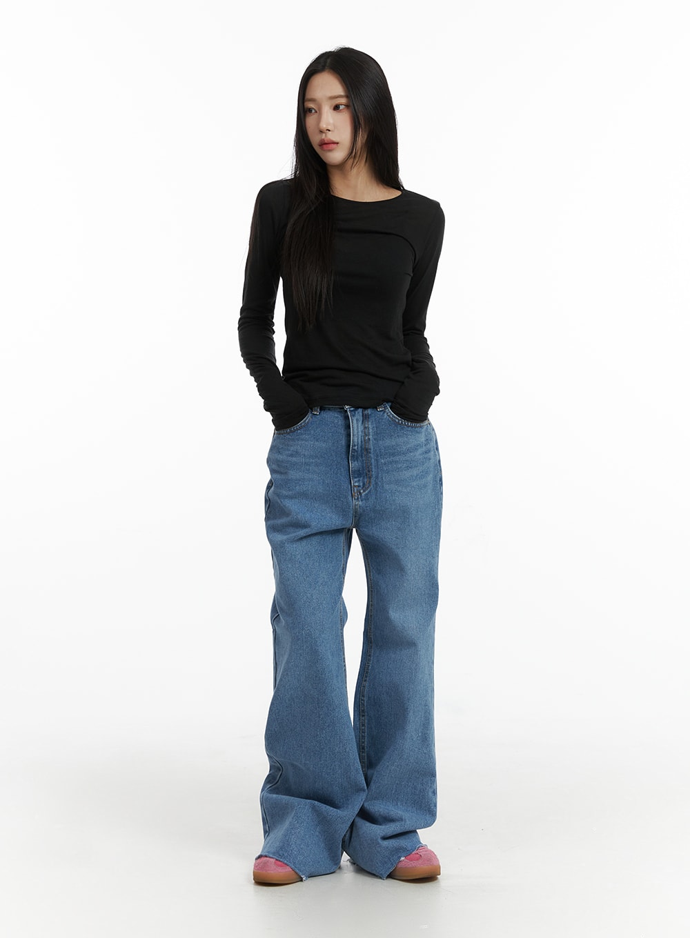 Blue Denim Bootcut Jeans CJ431 in blue, full-length front shot on model with hands in pockets, slim high-rise washed denim, wide bootcut flare, styled with black long sleeve top and pink mules.