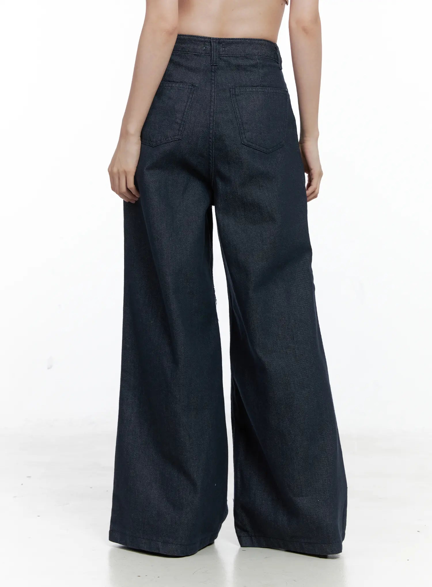 Lena Pintuck Baggy Jeans CO503 in dark blue, back close-up on model (cropped at waist), emphasizing two large patch pockets and wide-leg flare in solid cotton denim.