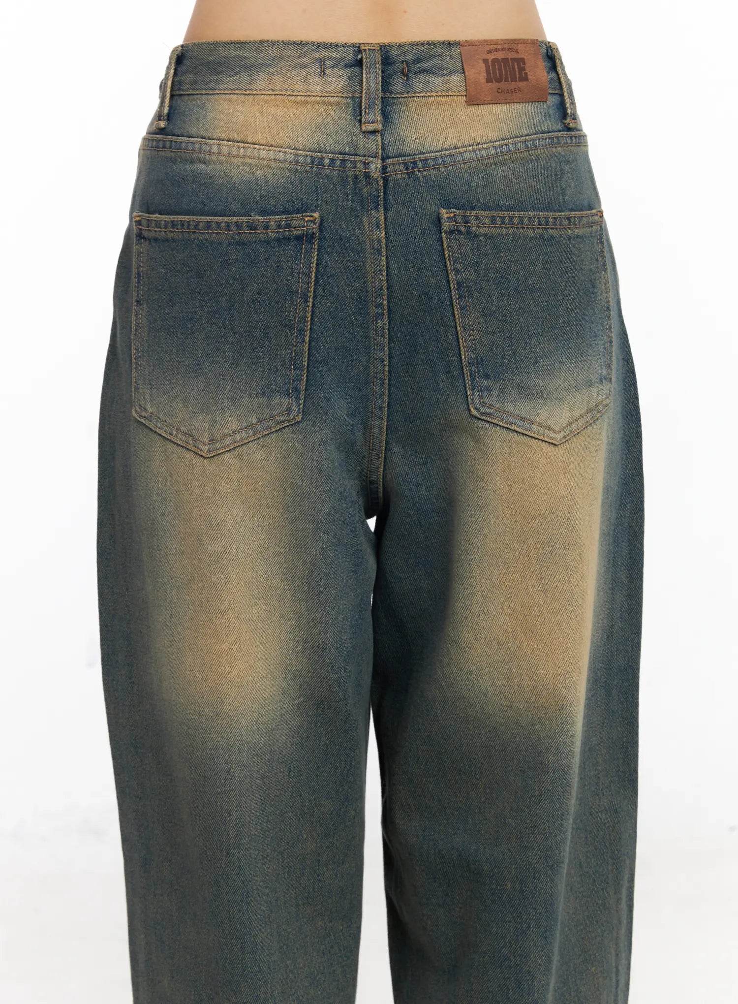Karsyn Vintage Baggy Jeans CJ522 in dark blue, back close-up detail on model, showing dual back pockets, leather brand patch, and amber sun-faded wash on cotton denim.