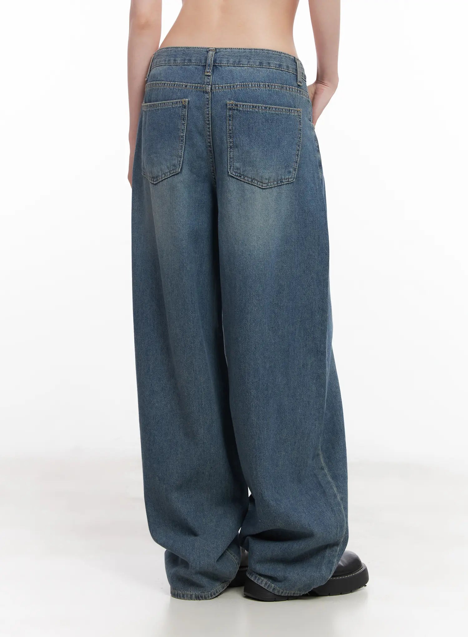 Chaewon Washed Wide-Leg Jeans CU511 in blue, back view on model, dual back patch pockets, washed denim with seam detail, ultra-wide leg hem pooling over black loafers.