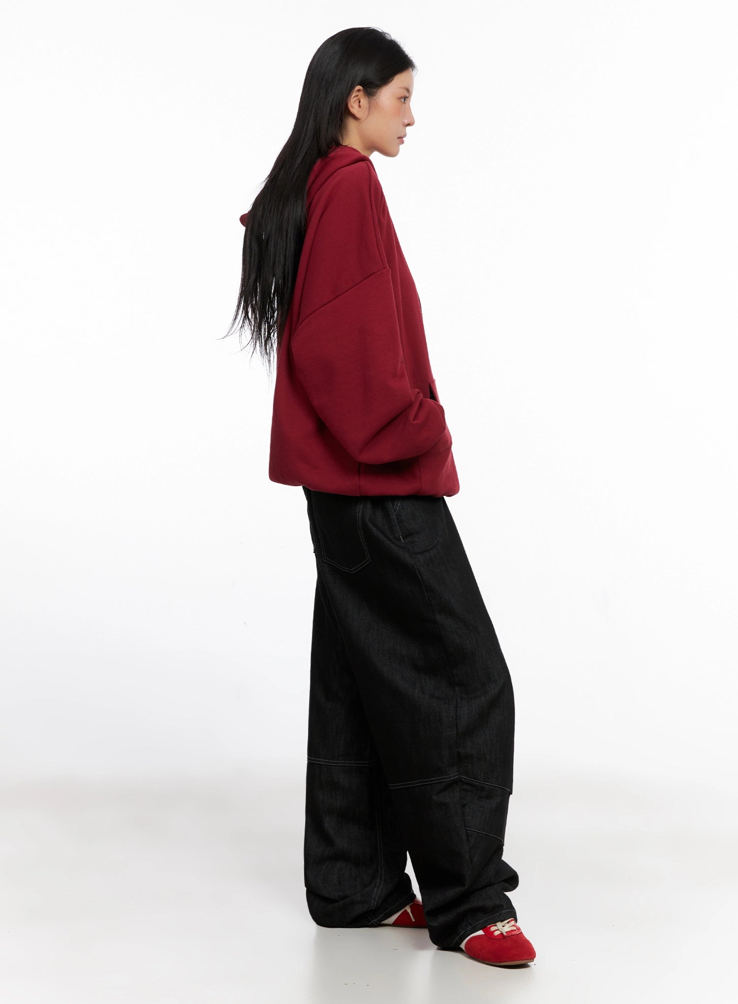 Leyla Pin-Tuck Wide-Leg Jeans IS515 in black, side view on model paired with red hoodie, full-length profile showing exaggerated wide-leg drape and pintuck panel seams.