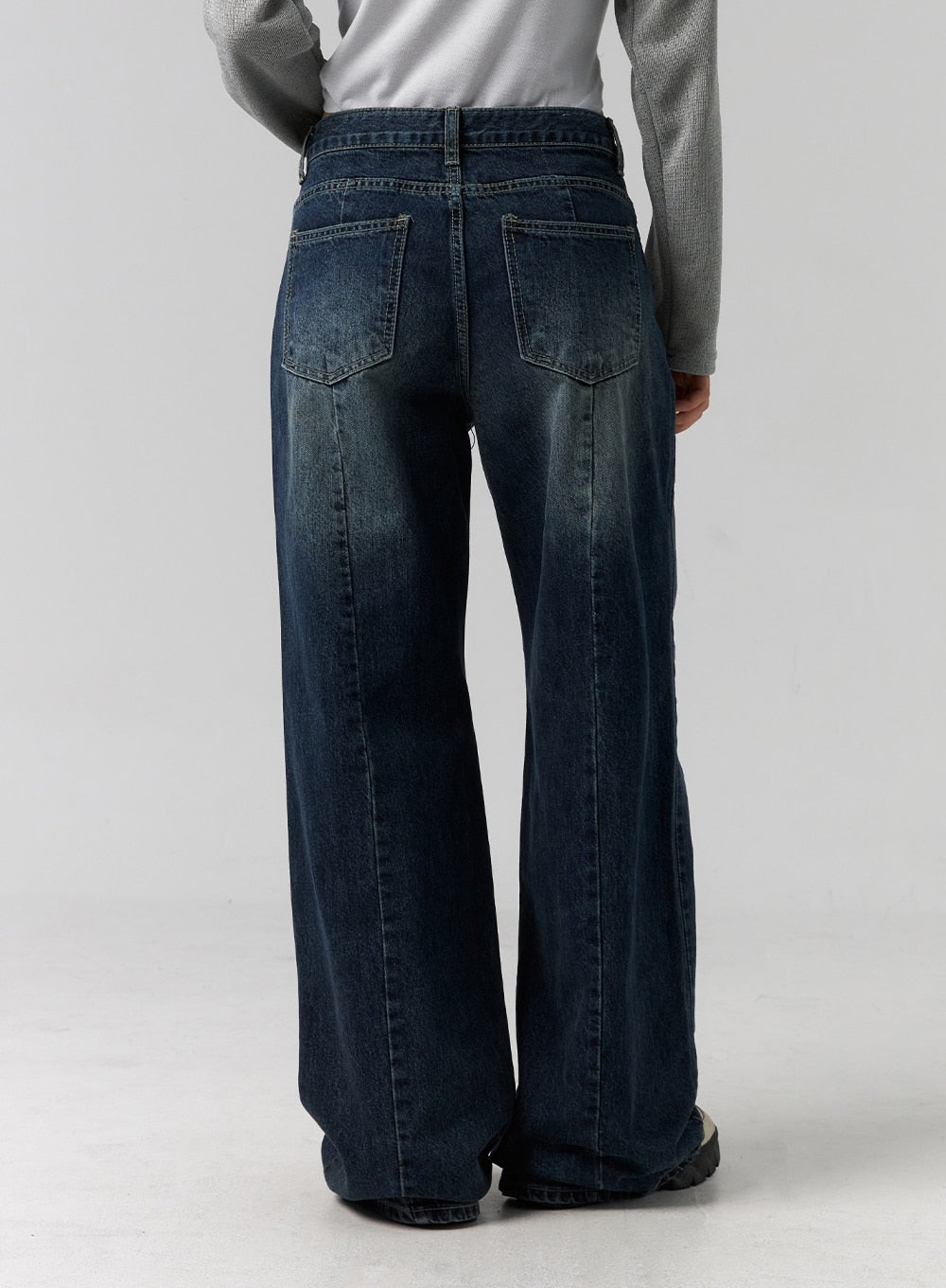 Low Rise Washed Wide Jeans CG315 in dark blue, back view from waist to hem on model, two back patch pockets, washed denim with fading across seat and thighs, wide flared leg opening.