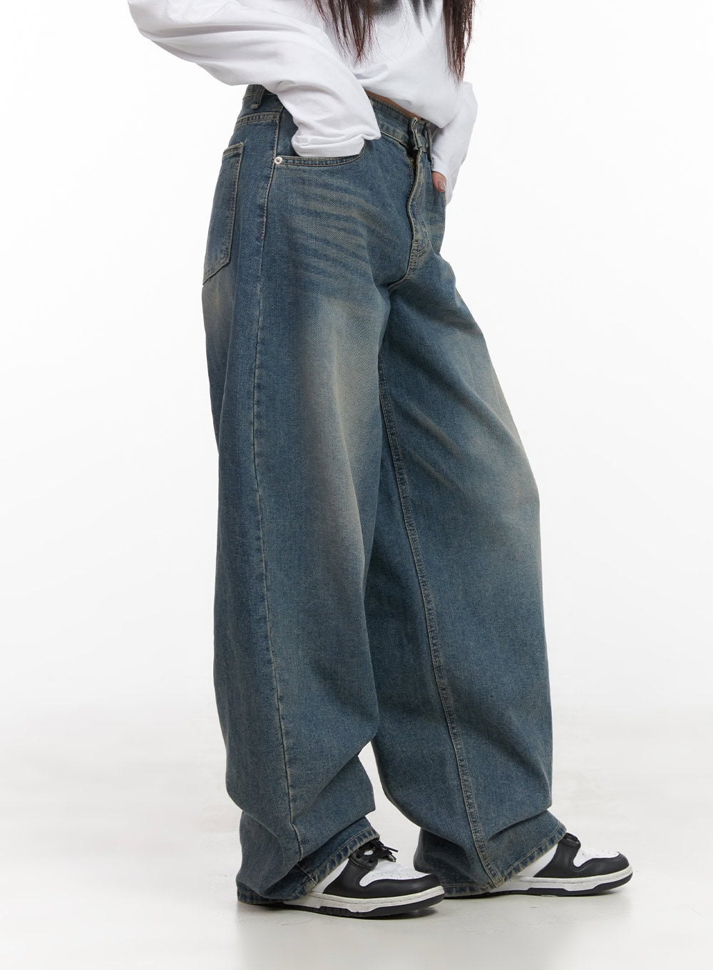 Mikaela Comfy Baggy Jeans CD411 in blue, side close-up from waist to hem on model, washed denim with seam detail and exaggerated wide leg, side pocket visible, paired with sneakers.