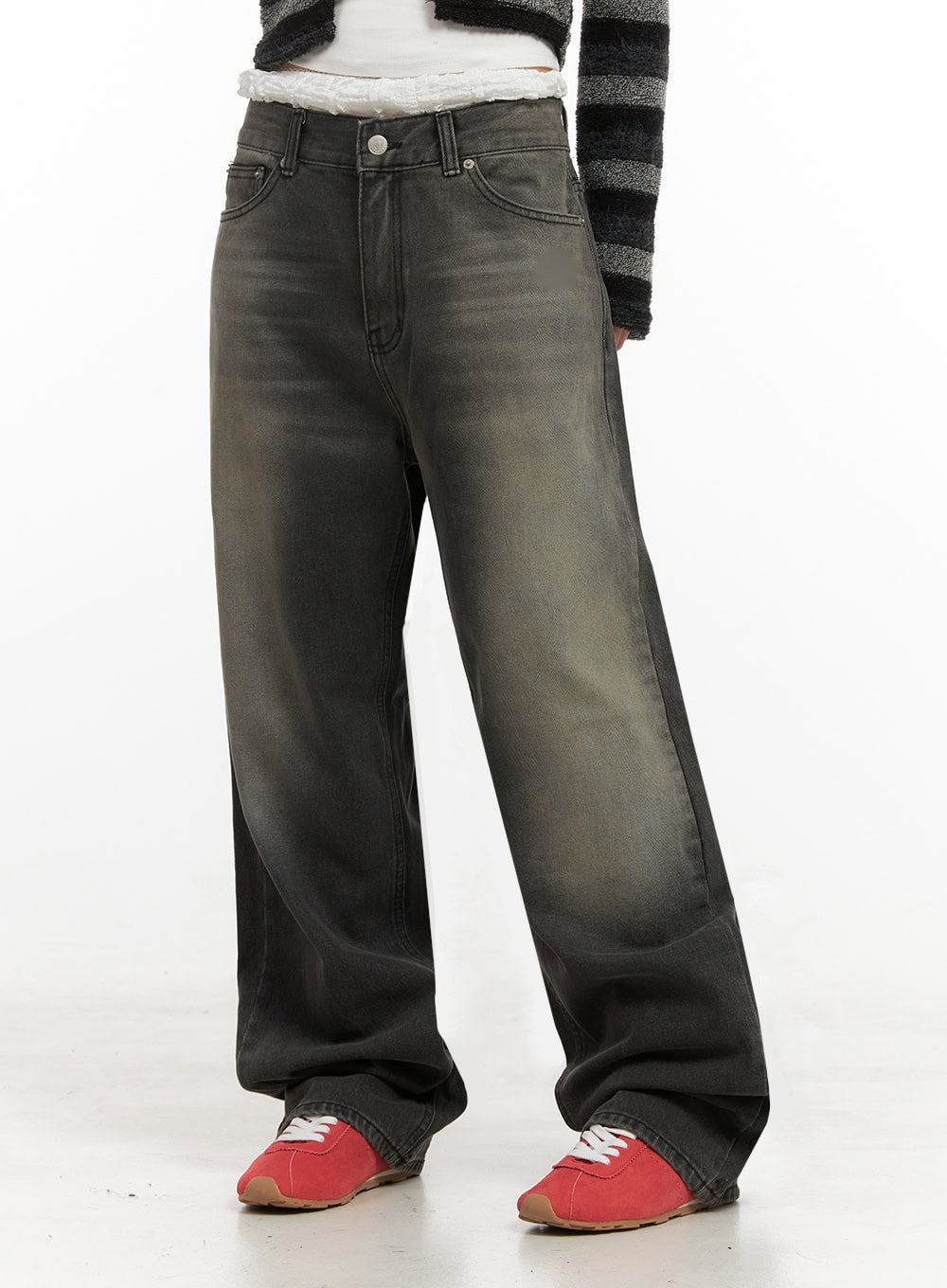 Matilda Wide-Fit Baggy Jeans ID402 in black, front side-angled cropped shot on model, washed denim showing faded highlights across wide leg, hem stacking over red sneakers.