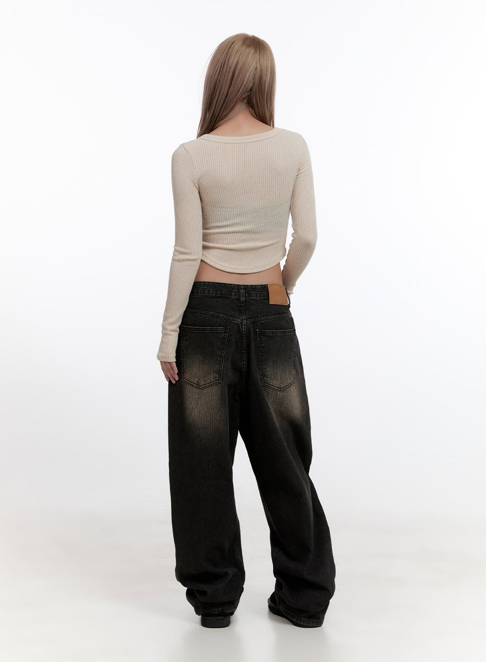 Sabina Low Waist Wide Fit Denim Jeans CN425 in Black, full-body back view on model, low-rise waistband with leather patch, wide baggy leg in washed black denim, paired with cream ribbed long-sleeve crop top.