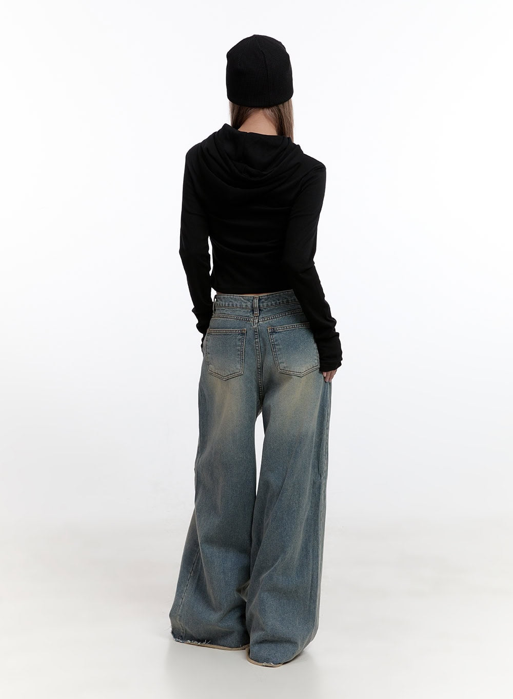 Felicia Cotton Wide Fit Baggy Jeans CN425 in blue, full-body back view on model, washed wide-leg denim, back patch pockets, frayed hem pooling at ground, paired with black cropped hoodie and beanie.