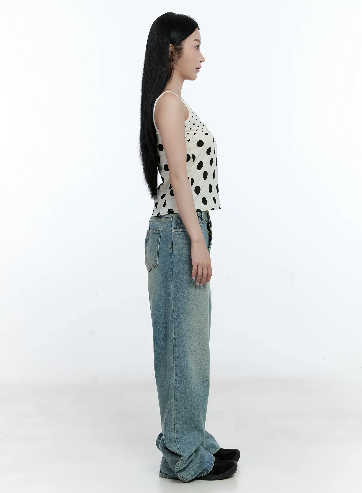 Haeun Wide-Leg Denim Jeans CG501 in blue, side profile view on model, showcasing full-length wide-leg silhouette with side seam and bunched hem, styled with a polka-dot cami.