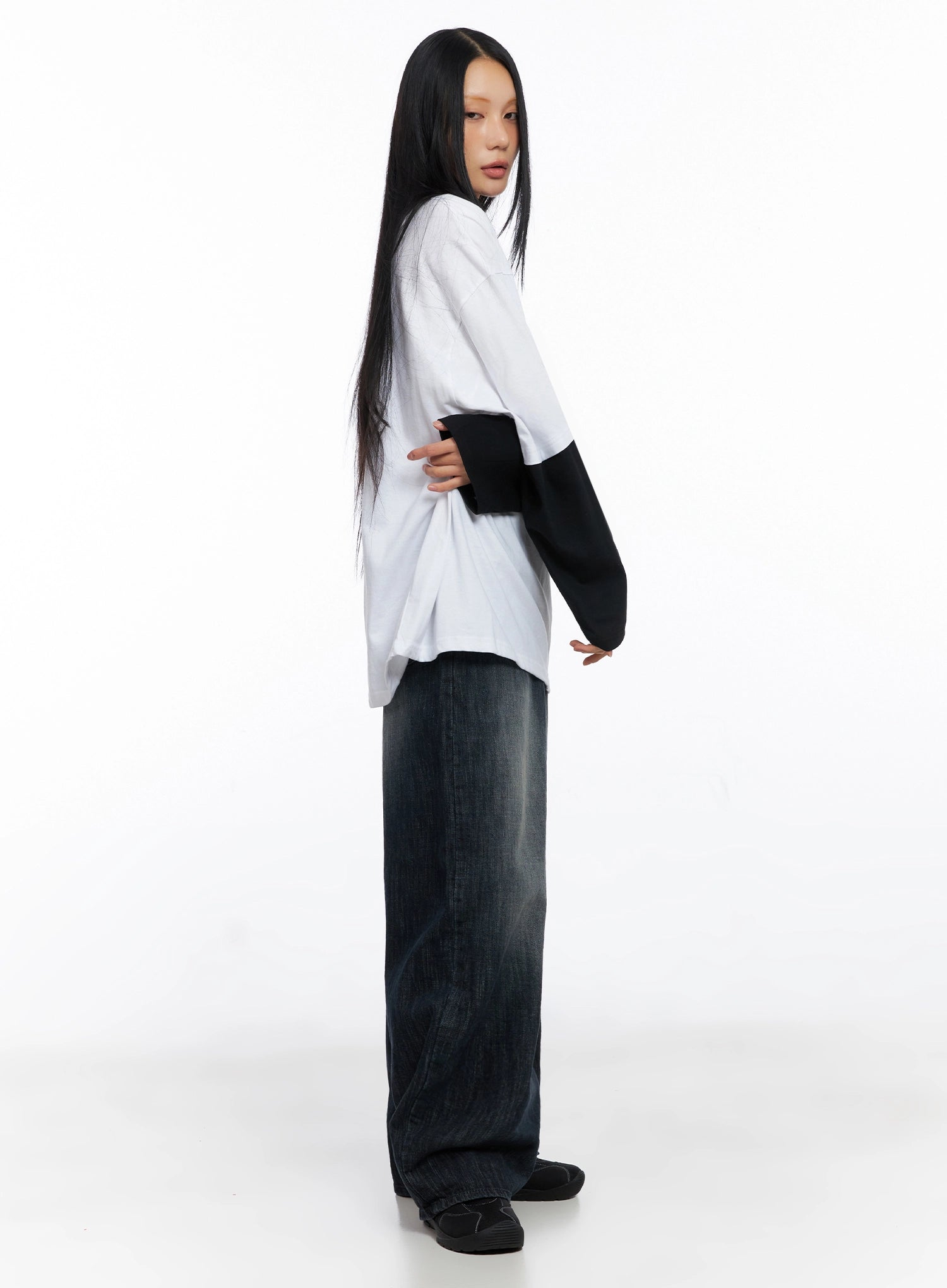 Minnell Vintage-Wash Wide-Leg Jeans IO517 in dark blue, side view on model in white layered top, highlighting ultra-wide leg silhouette and long inseam pooling at black sneakers.