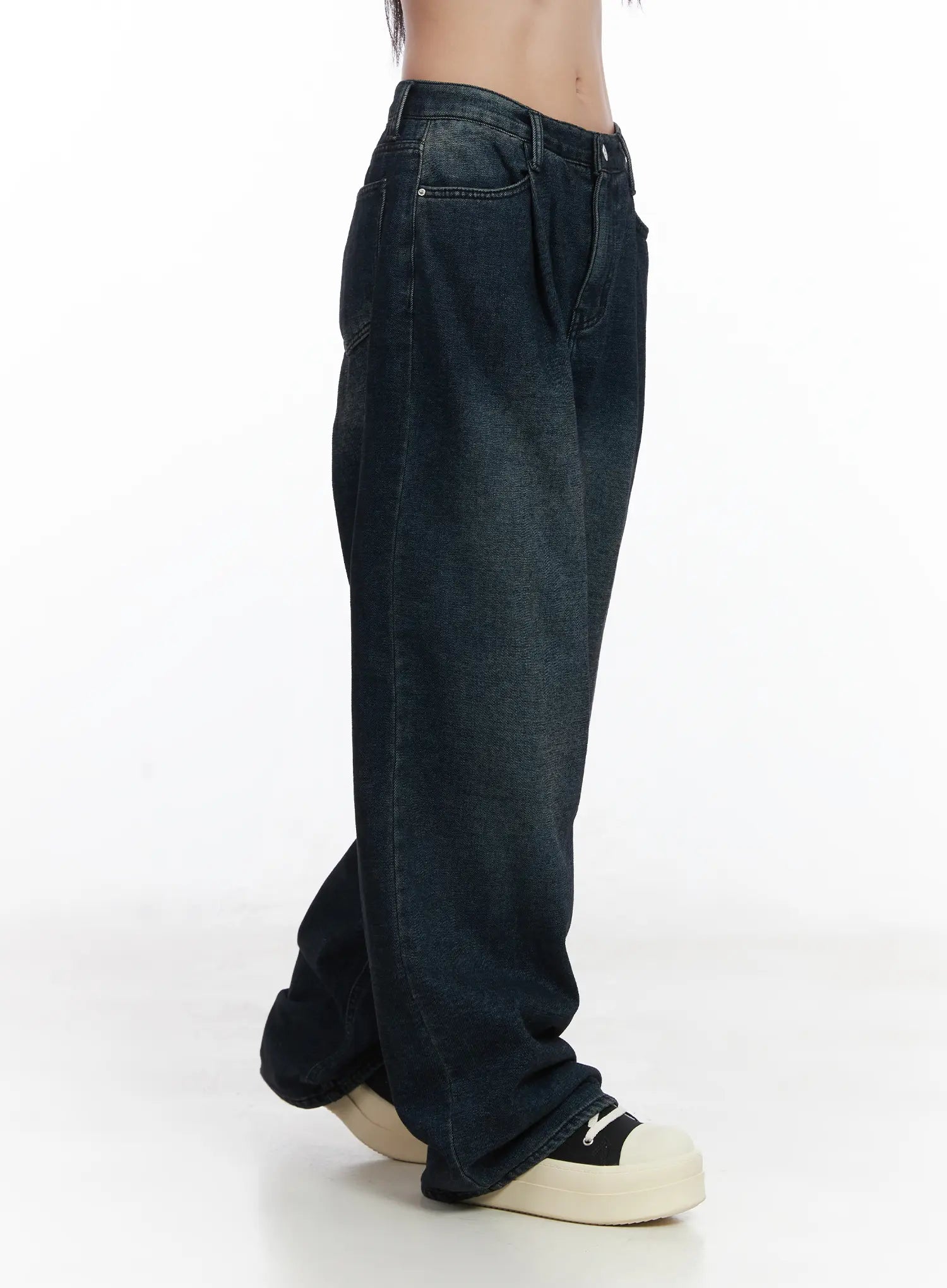 Lettie Fleece Pintuck Wide Leg Jeans CD529 in dark blue, side close-up from waist to hem on model, pintuck pleat and washed finish visible, oversized wide leg with stacked hem over sneakers.
