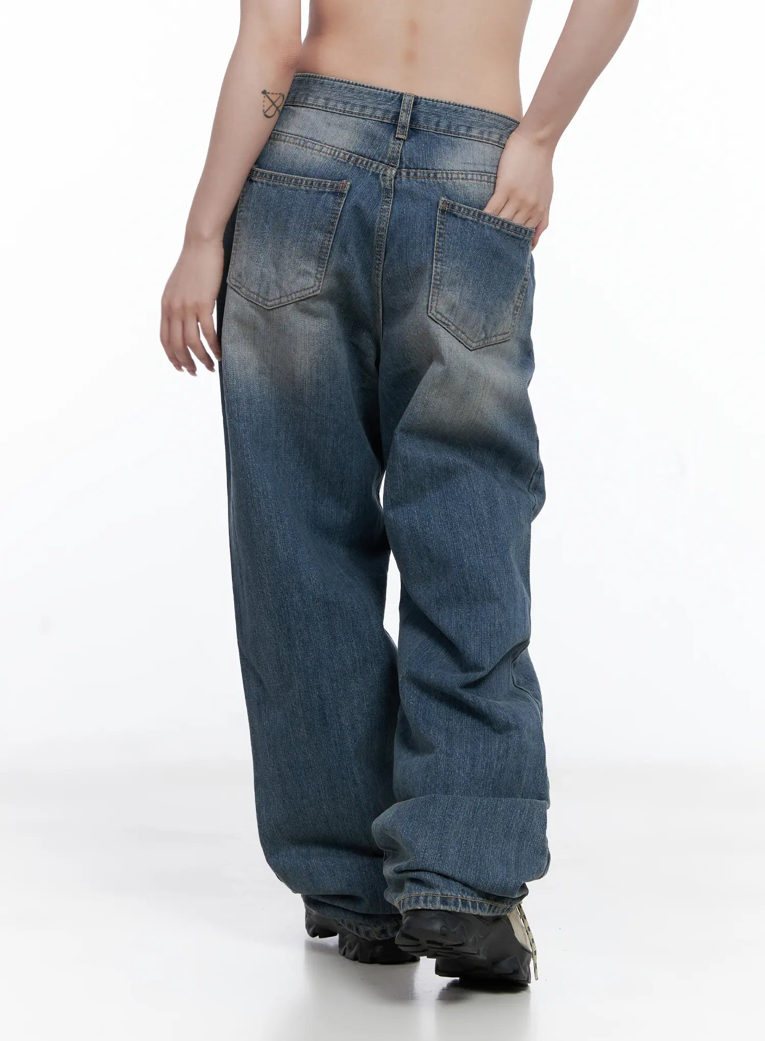 Lala Wide Leg Vintage Washed Jeans CG529 in blue, back view on model, showing two back pockets, vintage whiskering, extra-wide leg hem pooling over chunky boots.