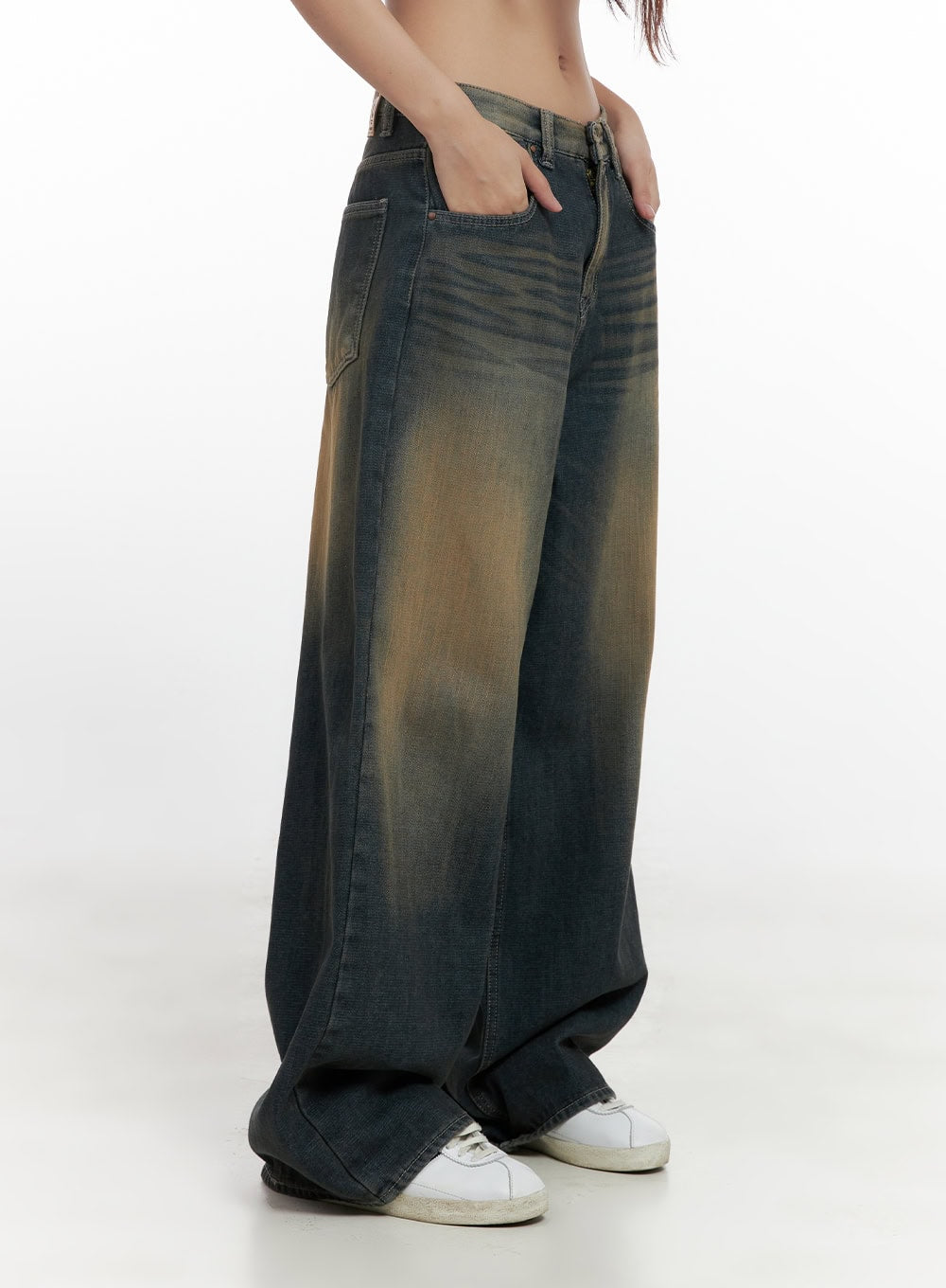 Bryana Cotton Comfort Wide Leg Jeans CN419 in dark blue, side close-up on model, amber sun-faded denim detail, relaxed wide leg with pooling hem, hand tucked in front pocket, white sneakers.