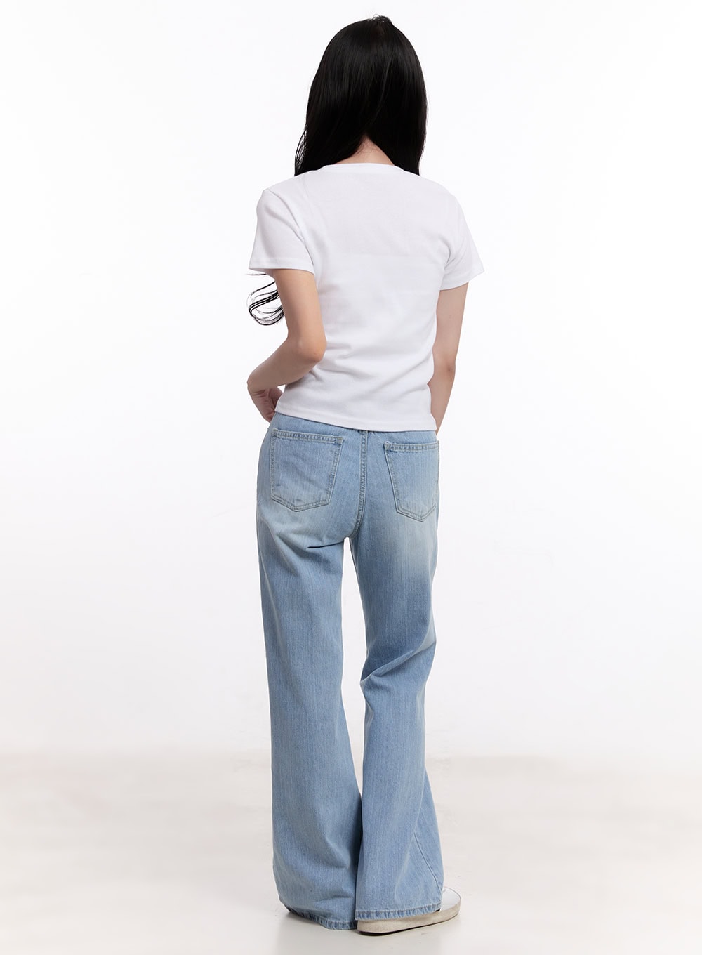 Daniella Relaxed-Fit Flared Jeans CM526 in light blue, back full-length shot on model, showing dual back pockets and flared bootcut hem, styled with white tee.