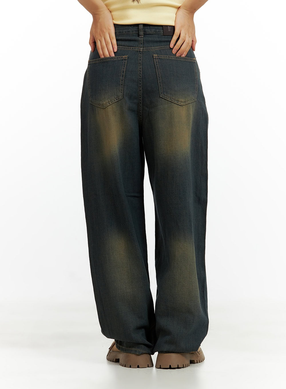 Vintage Washed Denim Baggy Pants CU420 in dark yellow, back waist close-up on model, showing dual back pockets, belt loops, and sun-faded yellow vintage wash pattern.