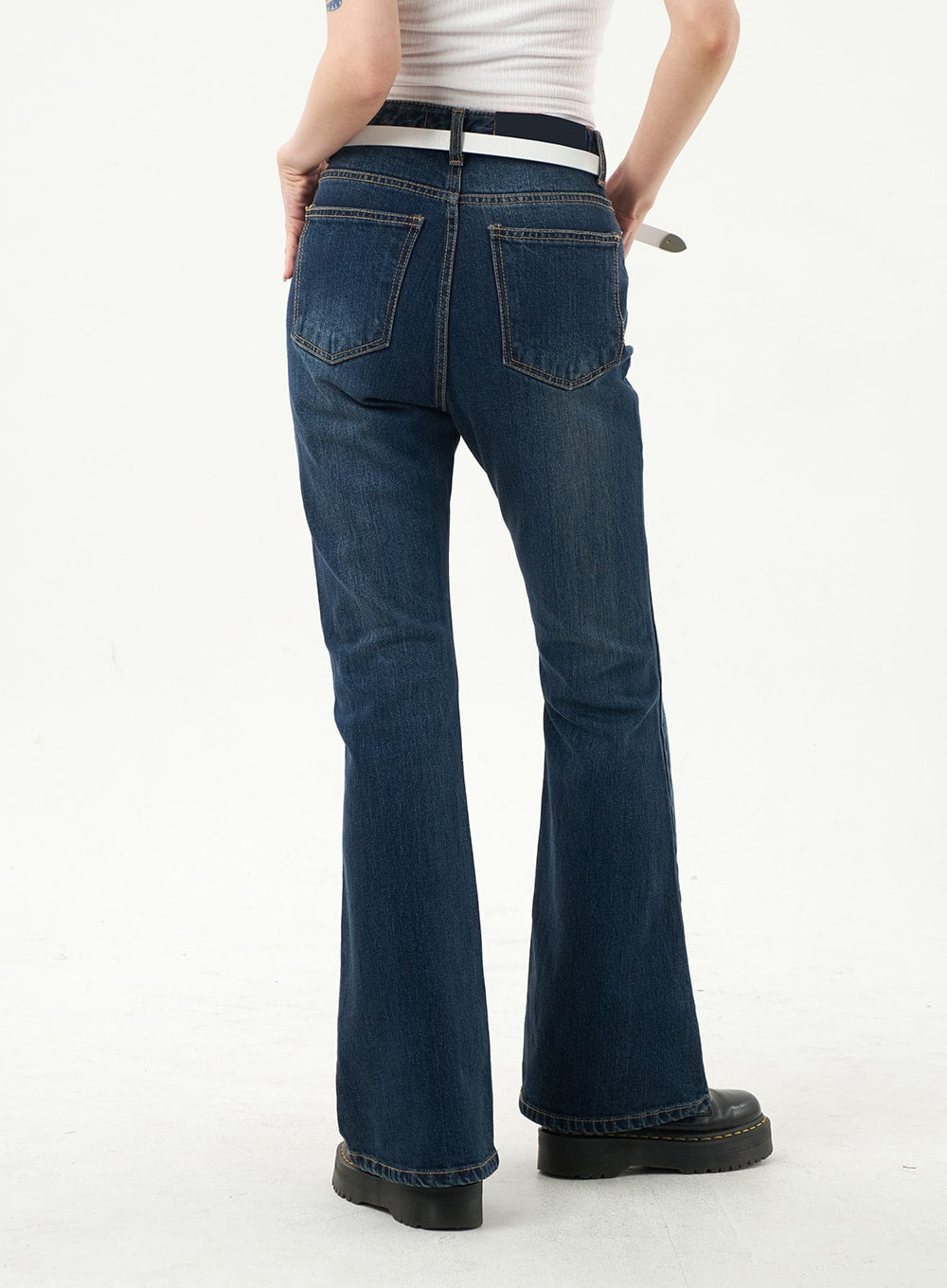 Dark Wash Bootcut Jeans CA328 in dark blue, back cropped view on model, two rear patch pockets with topstitching, white belt at high waist, flared hem visible.