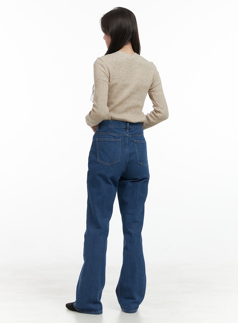 Tessa Straight Jeans OG412 in blue, back full-body view on model, straight-fit washed denim with back pockets, styled with beige ribbed knit top and black flats.