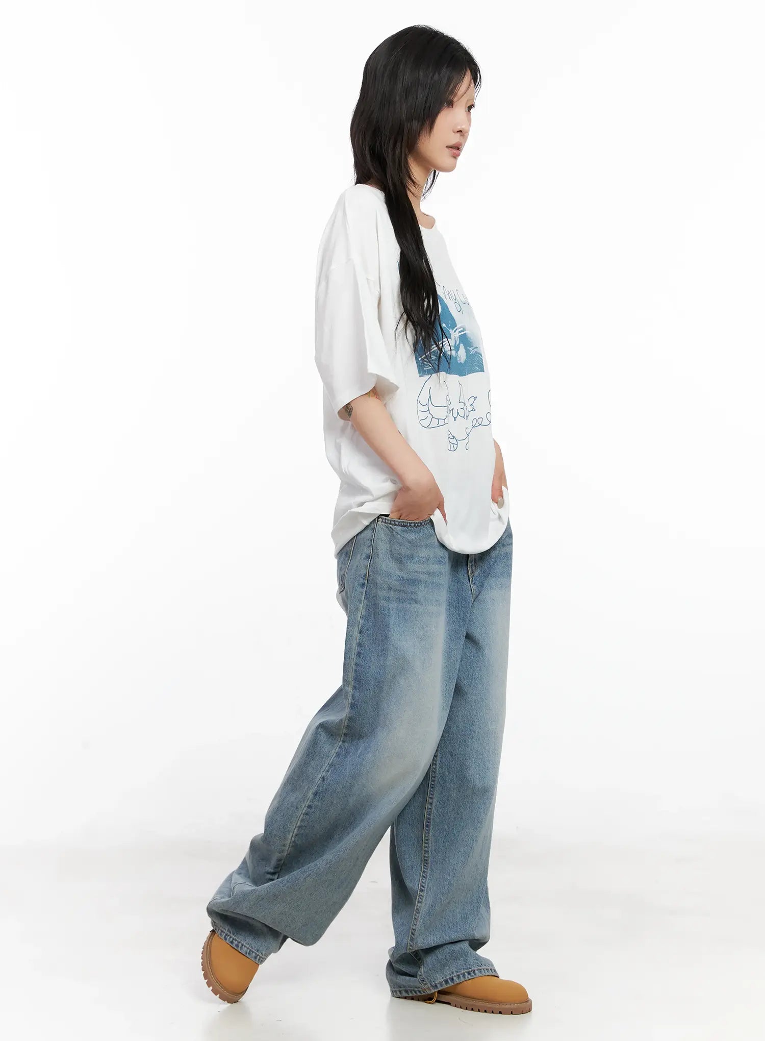 Koko Vintage-Wash Baggy Jeans CL528 in blue, side full-length on model mid-stride, baggy wide-leg fit with faded wash, styled with oversized white graphic tee.