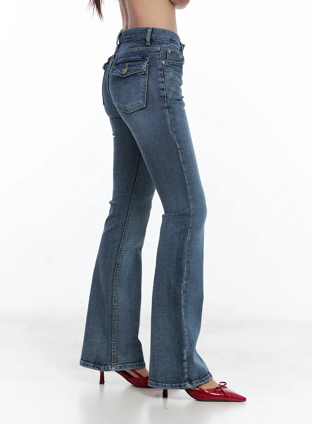 Beni Washed Flared Denim Jeans CL508 in dark blue, side close-up on model, back flap pocket and seam line detail visible, mid-rise bootcut silhouette with red heels.