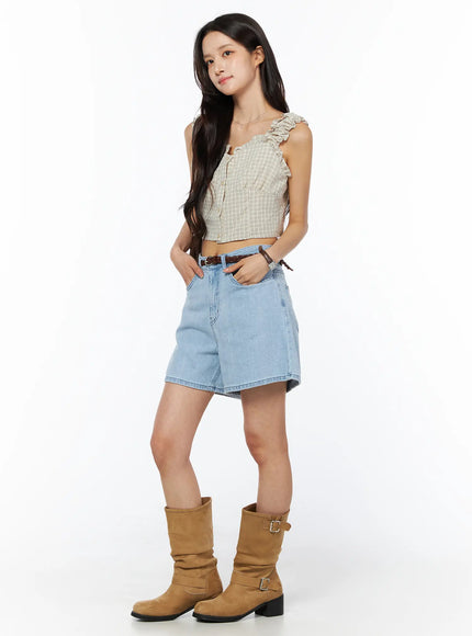 Plaid Ruffle Sleeveless Top CU522 in beige, 3/4 side full-body shot on model, cropped plaid top with ruffled straps, styled with denim shorts, braided belt, and tan buckle boots.